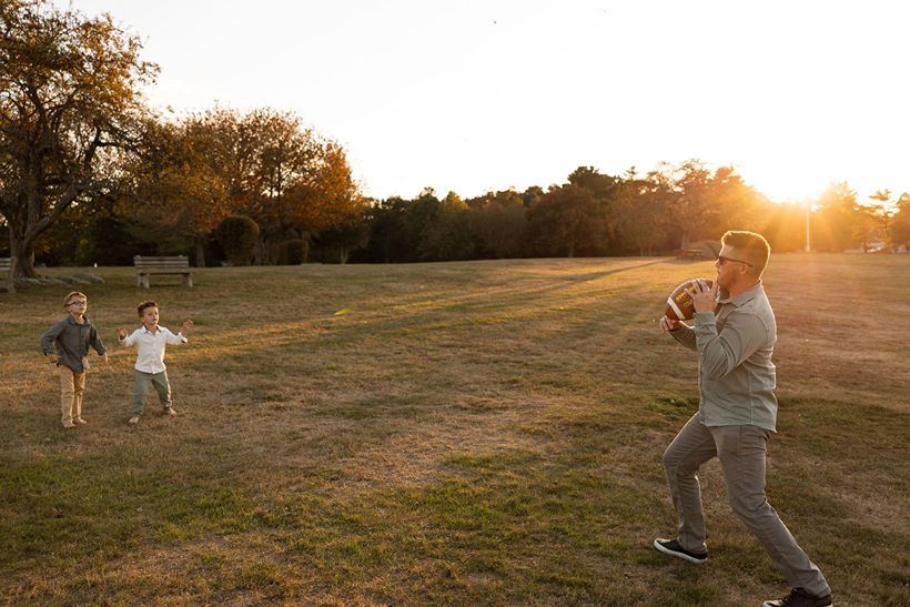 father and sons throw the football during their documentary style family photos 