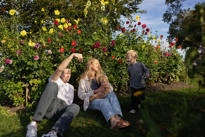 family sits together in the flower garden