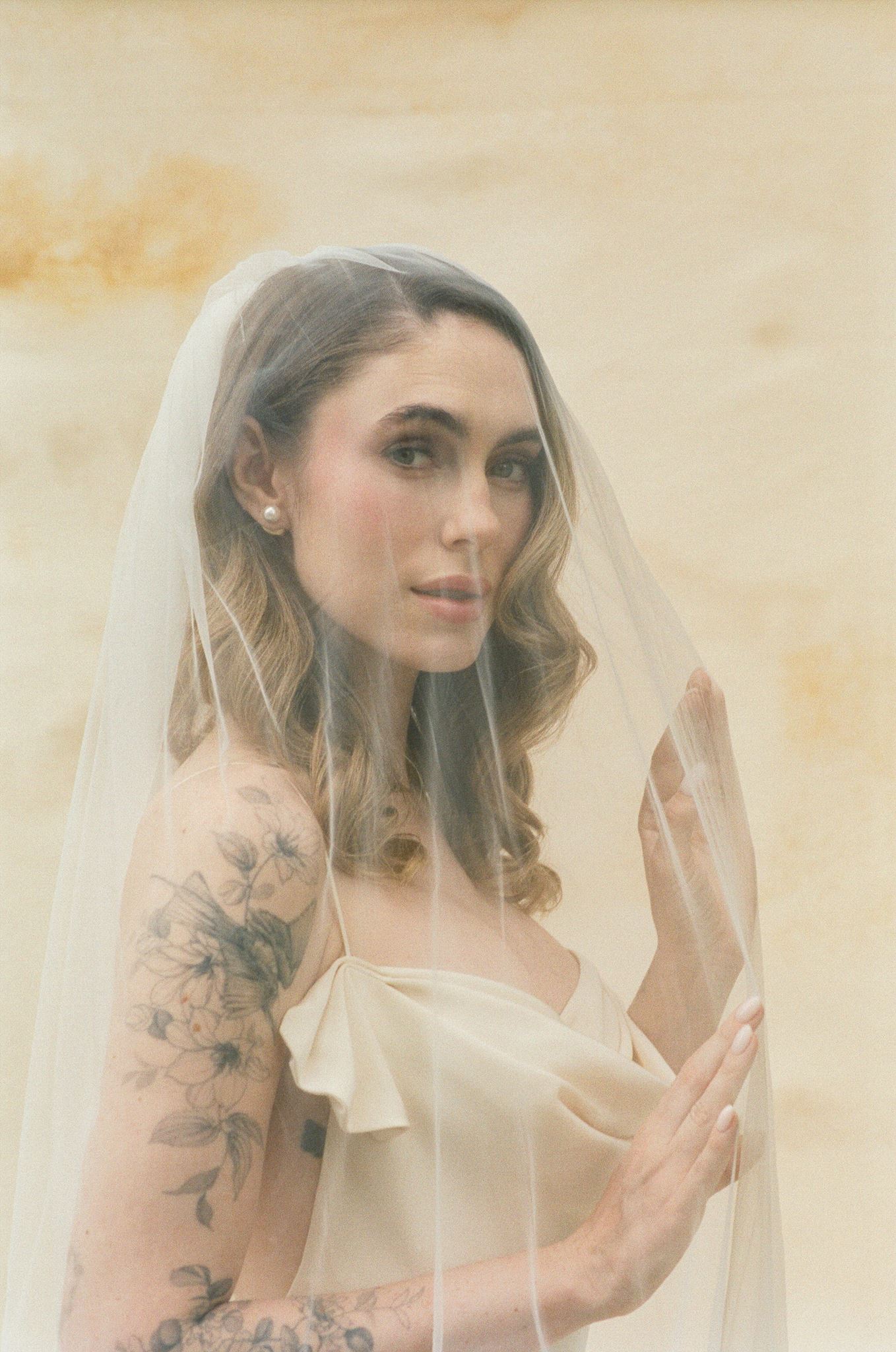 beautiful bride poses for a photo with the veil over her head