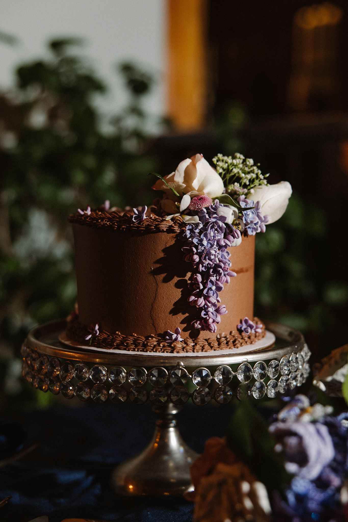 stunning intimate wedding cake with flowers dangling down the side and hanging on the top